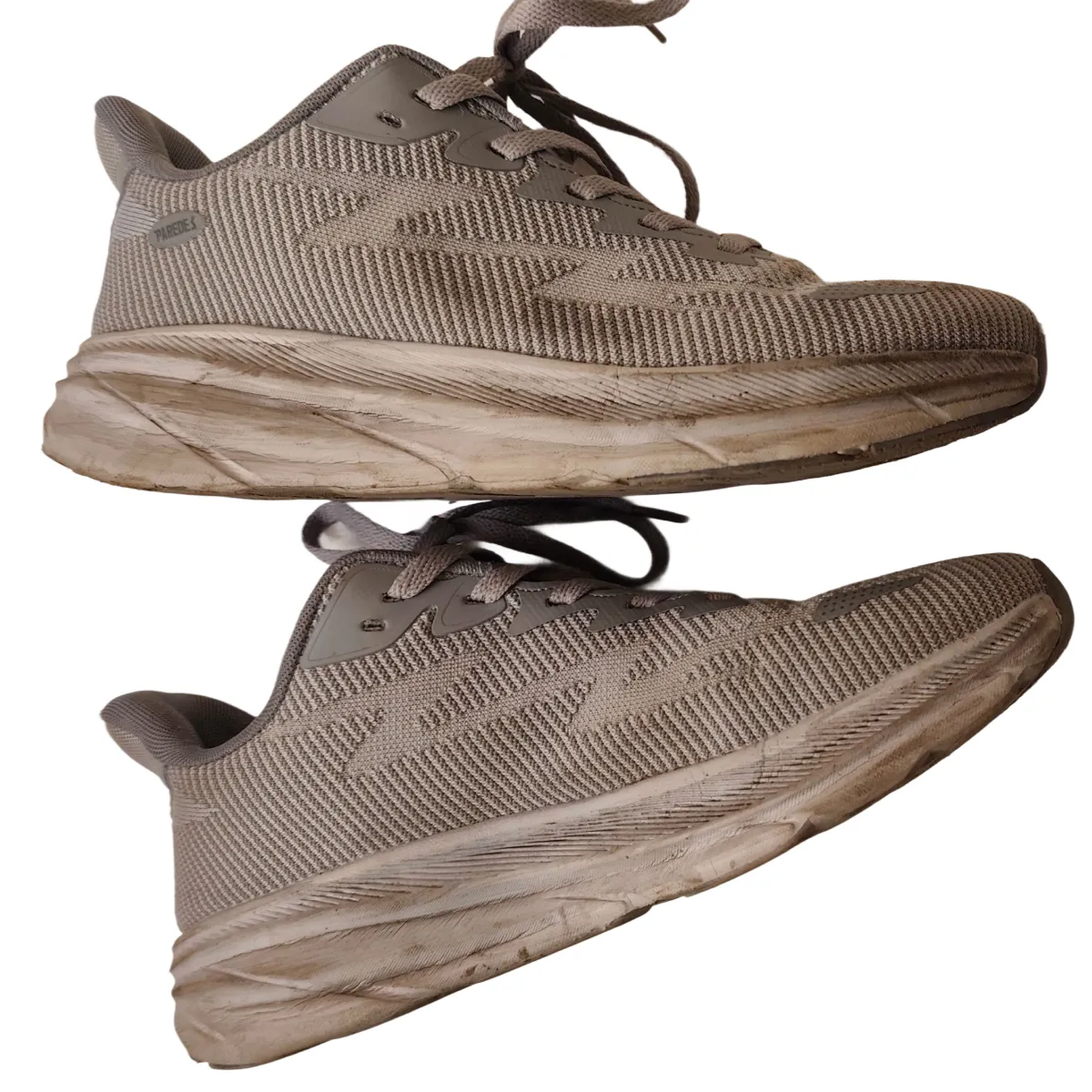Side view of dirty grey mesh sneaker with soiled midsole before cleaning