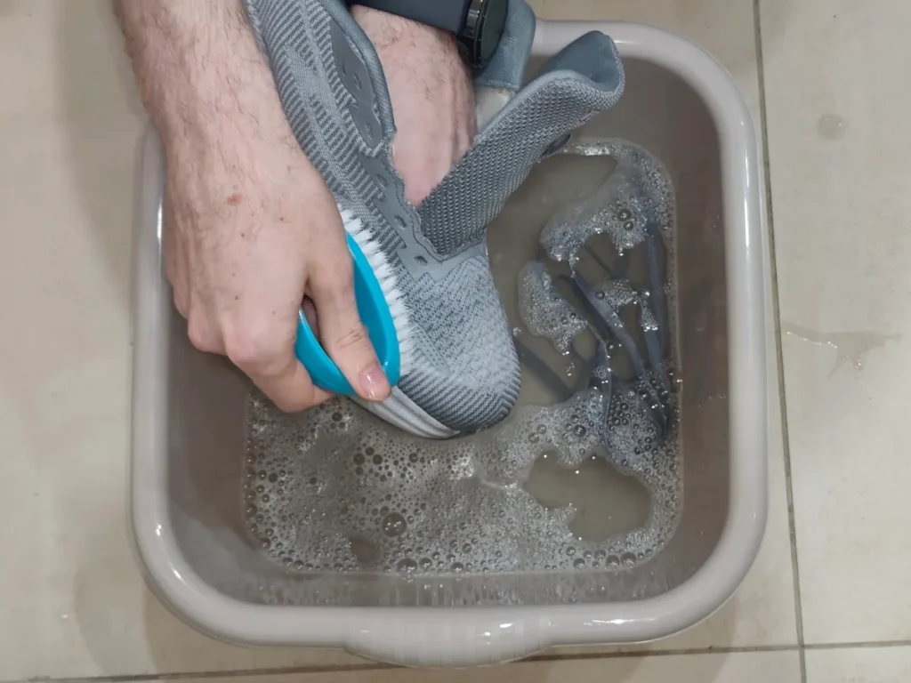 How to wash sneakers by hand — setup with soft brush, toothbrush and soapy water.